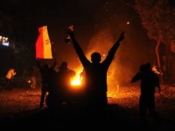 Varias personas prenden fuego a las puertas del palacio presidencial de Itihadiya. EFE /