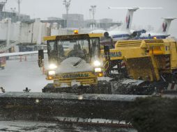 Una barredora de nieve limpia la zona de la pista de aterrizaje en un aeropuerto de Nueva York. AP /