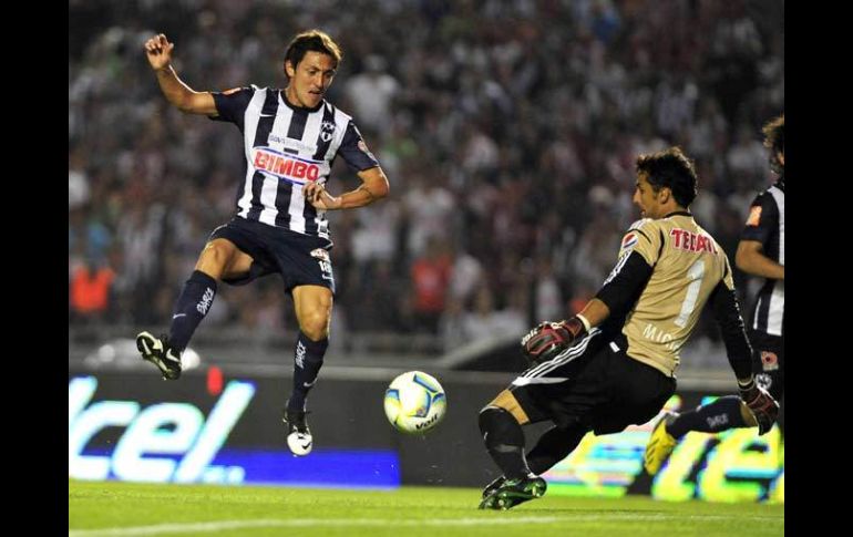 Cardozo dispara ante la salida del portero Luis Michel en el juego entre Rayados y Chivas. EFE /