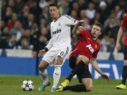 Acción del partido entre Real Madrid y Manchester United donde Özil trata de quitarse la marca de Carrick. EFE /