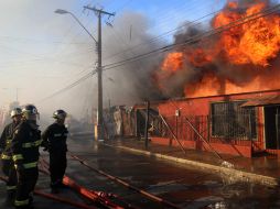 Bomberos participan en las labores de extinción de un incendio. EFE /