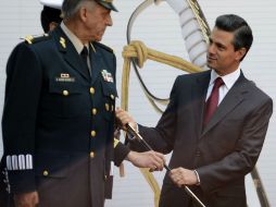 Salvador Cienfurgos, secretario de la Defensa Nacional, entrega la espada de mando como muestra de lealtad al gobierno. AFP /