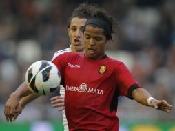 Dos Santos (frente) no puede hacer mucho para evitar la caída de su equipo. Guardado lo marca excelente. EFE /