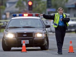 La polícía local desvía el tráfico de la escena del crimen. AP /