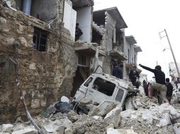 Varios residentes que caminan entre los escombros de un edificio en el barrio de Tariq al Bab, en Alepo. EFE /
