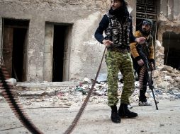 Integrantes sirios armados de las fuerzas rebeldes esperan para disparar a un helicóptero . EFE /