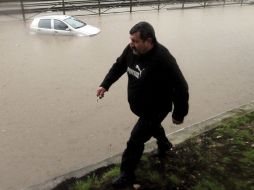 Un hombre camina por las calles inundadas de Atenas, Grecia. EFE /