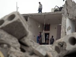 Una familia siria limpia su casa destruida después del impacto de un misil. EFE /