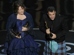 Los directores Mark Andrews y Brenda Chapman suben al escenario para tomar la estatuilla dorada.  /