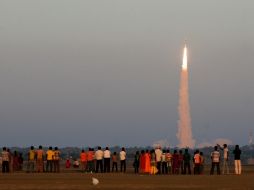 El lanzamiento del cohete portador de los satélites es observado por un grupo de personas hoy, en la India. AP /