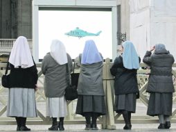 El Adiós. Religiosas miran en una pantalla gigante desde la Plaza de San Pedro, el trasbordo de Benedicto XVI a Castelgandolfo. AFP /
