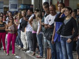 Un grupo de personas espera algún medio para movilizarse en la ciudad. EFE /