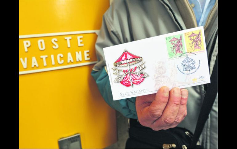Recuerdo. Un hombre sostiene un sobre con la estampilla creada para usarse durante el periodo que consigna la Sede vacante. AFP /
