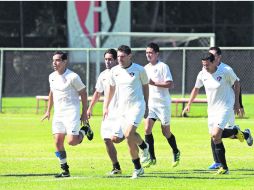 Omar Bravo, Amaury Ponce y Leandro Cufré realizan ejercicios en la cancha del Atlas Colomos. EL INFORMADOR /