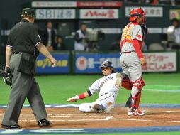 Yoshio Itoi, de Japón, se barre en el home ante el catcher Wang Wei de China. AFP /
