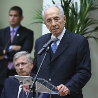 Peres inicia su gira europea condecorando a 22 belgas