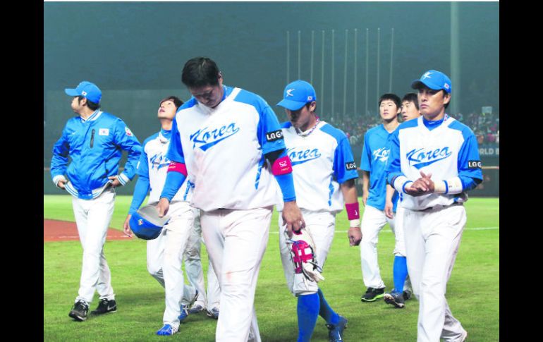 Caras largas. Los jugadores de Corea del Sur se retiran del diamante, tristes luego de no lograr su boleto a la segunda ronda. EFE /