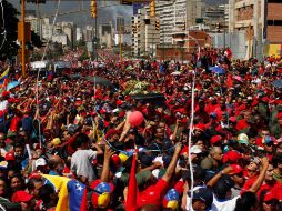 Miles de venezolanos salieron a las calles de Caracas para acompañar los restos del presidente Hugo Chávez. AP /