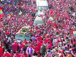 Miles de seguidores acompañan el féretro con los restos del presidente Hugo Chávez, camino a la  Academia Militar. AFP /