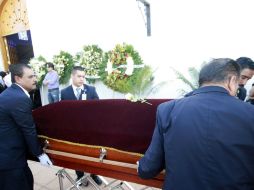 Cuatro hombres mueven el ataúd con los restos de Gallegos. NTX /