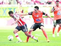 Luis Pérez quien disputa un balón con Héctor Herrera, reapareció en la oncena rojiblanca tras recuperarse de una lesión. EL INFORMADOR /