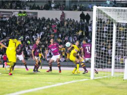 El defensa Diego Reyes, del América (amarillo), trata de frenar un ataque de los universitarios. EL INFORMADOR /