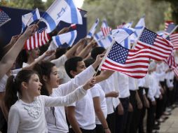 Varios niños ondean banderas de Estados Unidos y de Israel durante los preparativos para la visita del presidente estadounidense. EFE /