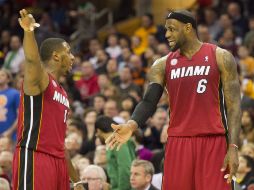 LeBron James (izq) da indicaciones a uno de sus compañeros durante el partido. AP /