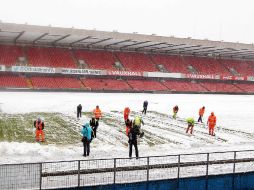 Voluntarios retiran la nueve del estadio Windsor Park de Belfast. AP /