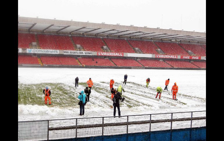 Voluntarios retiran la nueve del estadio Windsor Park de Belfast. AP /