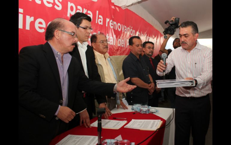 Contreras Zepeda (d) entrega su documentación ante integrantes de la Comisión Estatal de Procesos Internos del PRI Jalisco. ESPECIAL /