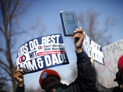 Detractores del matromonio gay portan letreros de ''a los niños les va mejor con un papá y una mamá''. AP /