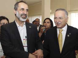El líder de la opositora CNFROS, Ahmed Muaz al Jatib (i), estrecha la mano del secretario general de la Organización de la Conferencia. EFE /