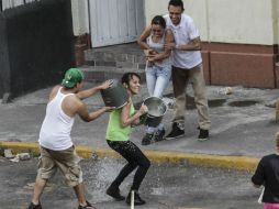 Este día de Sábado de Gloria, las personas acostumbran arrojar el líquido contra otras, sólo con el propósito de jugar. NTX /