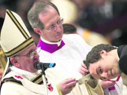 Tradición. Francisco bautiza a un hombre, como es parte del ritual de la vigilia. EFE /