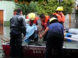 Una mujer es evacuada por un cuerpo de bomberos en La Plata. EFE /