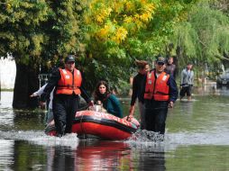 Rescatistas ayudan a los damnificados tras la inundación en La Plata. EFE /