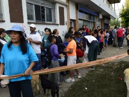 Las personas afectadas hacen filas para recibir agua y comida en La Plata, Buenos Aires. AFP /