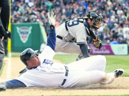 Miguel Cabrera anota antes de que el catcher de los Yankees, Francisco Cervelli, pueda tocarlo, en la quinta entrada. AP /