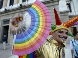 Un activista a favor del matrimonio entre homosexuales sostiene un abanico multicolor afuera del Parlamento uruguayo. AP /