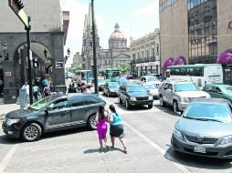 Riesgo para el peatón. En el Centro de Guadalajara los peatones deben sortear los autos para poder cruzar la calle. EL INFORMADOR /