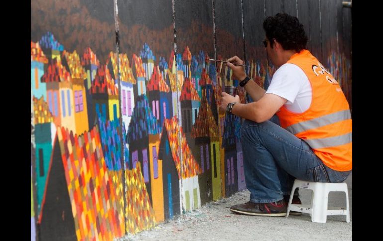 Un ayudante termina un mural en Quito, como parte de esta interesante propuesta artística. EFE /