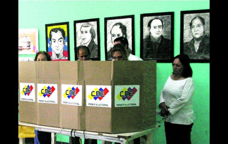 Efectivos militares del Plan República junto con miembros electorales revisan las máquinas de votación . NTX /