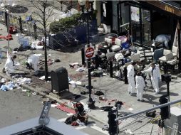 Investigadores examinan el lugar donde detonó la segunda bomba. AP /