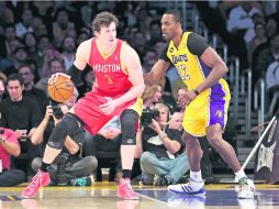 Arrastra marca. Omer Asik empuja al centro de los Lakers, Dwight Howard, en su camino a la canasta. AFP /