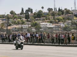 Los estudiantes son acompañados por la policía a su salida del plantel. AP /