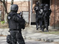 Agentes de diferentes corporaciones permanecen en la búsqueda de uno de los sospechosos. AP /