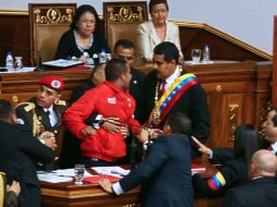 El sujeto, que vestía camisa roja y pantalón negro, logra quitarle el micrófono a Maduro. AFP /