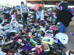 Junto a un albergue en West, Texas, voluntarios donan ropa y calzado para los afectados del estallido en la planta de fertilizantes. AFP /