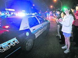 Vecinos aplauden al paso de una patrulla de Policía, tras conocer la detención del joven sospechoso de las explosiones en Boston. AP /
